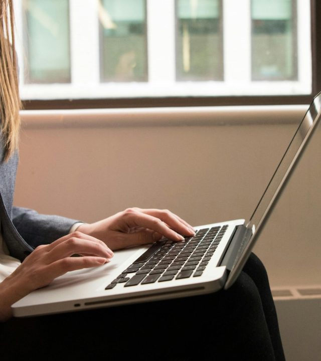 A woman working remotely on a laptop in a contemporary indoor office setting. Ideal for business or technology themes.